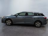 a grey car is parked in a room with a white wall