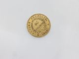a gold coin with a crown on it on a white surface