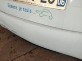 a white car with a sticker on the back of it ' s bumper