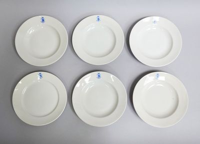 six white plates with blue writing on them sitting on a table