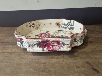 a small tray with flowers on it sitting on a wooden table