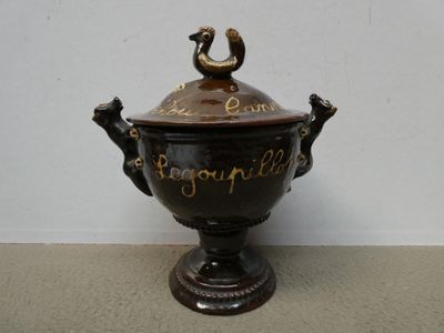 a brown vase with a bird on top of it