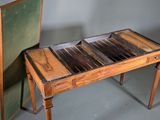 a small wooden table with a green chair next to it