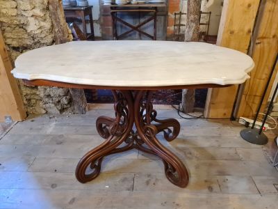 a table with a marble top in the middle of a room