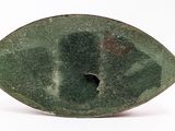 a green stone object with a hole in the middle of it