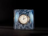 a clock that is sitting on a table in front of a black background