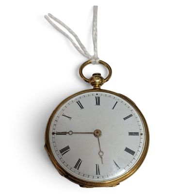 une montre à gousset en or suspendue à un mur blanc
