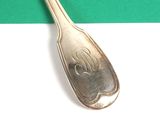 a silver spoon that is on a green and white table