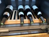 several bottles of wine are sitting on a rack in a wine cooler