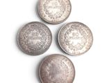 quatre types différents de pièces d'argent sur une surface blanche