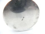 a close up of a silver object on a white surface