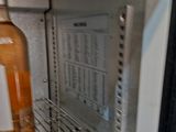 a bottle of alcohol sitting inside of an open refrigerator