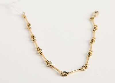 gros plan d'un collier à chaîne en or sur une surface blanche