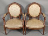 paire de fauteuils anciens français en bois sculpté, avec des assises rembourrées de couleur beige
