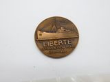 une image représentant une pièce de monnaie en bronze sur laquelle figure un bateau