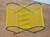 a yellow chair that is sitting on a tile floor