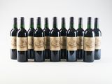 six bottles of wine are lined up in a row on a white surface