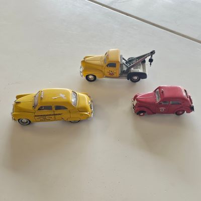 three toy cars sitting next to each other on a table