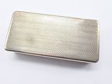a close up of a silver cigarette case on a white surface