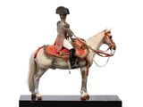 figurine of a man riding a horse on a black base