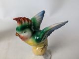a figurine of a bird sitting on a small base