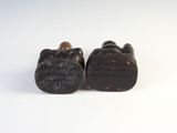 pair of antique carved wooden shoes with writing on them on a white surface