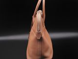 a brown leather handbag on a black background