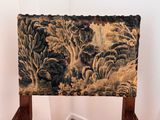 a chair that has a tapestry on the back of it