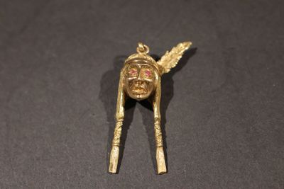 un gros plan d'une broche en or ornée d'un crâne