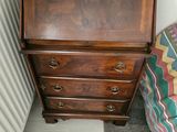 a small dresser with a wooden top in a room