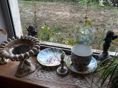 un rebord de fenêtre sur lequel sont disposés de nombreux vases et autres objets