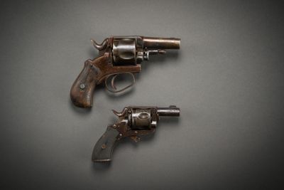 two old revolvers sitting on top of a table next to each other