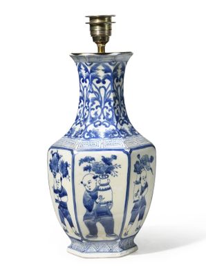 a blue and white vase with a lamp on top of it
