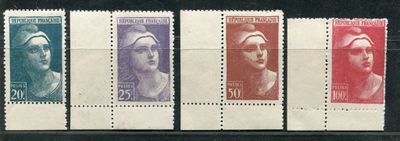 a group of four different colored stamps on a black surface