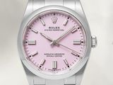 un gros plan d'une montre au cadran rose montée sur un bracelet