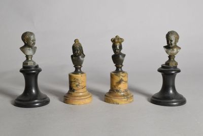 quatre pièces d'échecs en bronze et en marbre posées sur un fond blanc