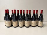 six bottles of red wine lined up in a row on a table