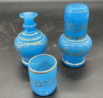 trois vases bleus posés les uns à côté des autres sur une table