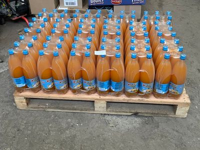 many bottles of orange juice sitting on a pallet