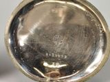 a close up of a silver pocket watch on a table