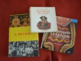 three books on a bed with a red comforter and a red blanket
