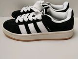 une paire de baskets noires et blanches posées sur une surface blanche