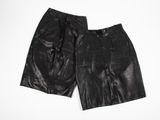 un short en cuir noir posé sur une surface blanche