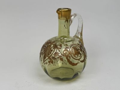 une bouteille en verre vert avec une poignée dorée sur un fond blanc