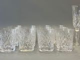 six glasses and a wine glass sitting on a table