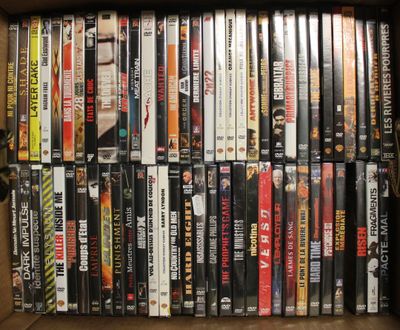 beaucoup de DVD dans une boîte posée sur l'étagère
