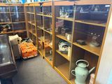 many glass shelves with teapots and other items on them