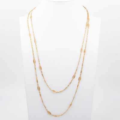un collier à chaîne en or composé de trois rangées de perles en or différentes
