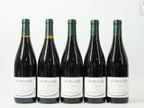 quatre bouteilles de vin sont alignées sur une surface blanche