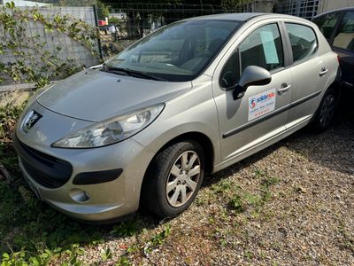 une petite voiture argentée garée à côté d'une voiture noire